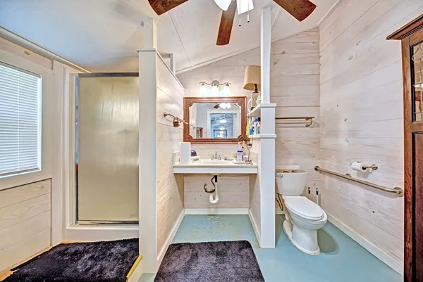 a bathroom with a sink a toilet and shower