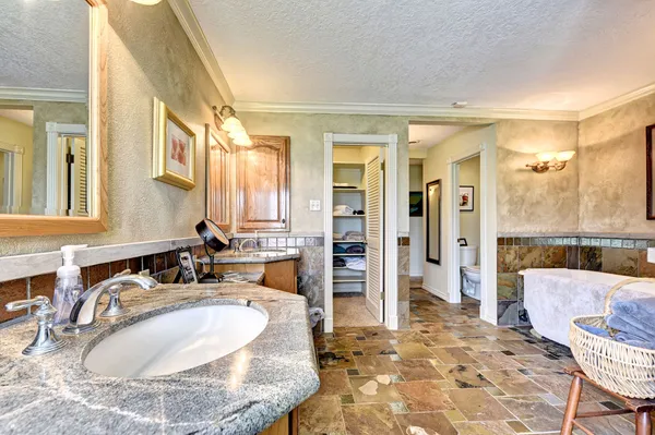 a bathroom with a tub sink and mirror
