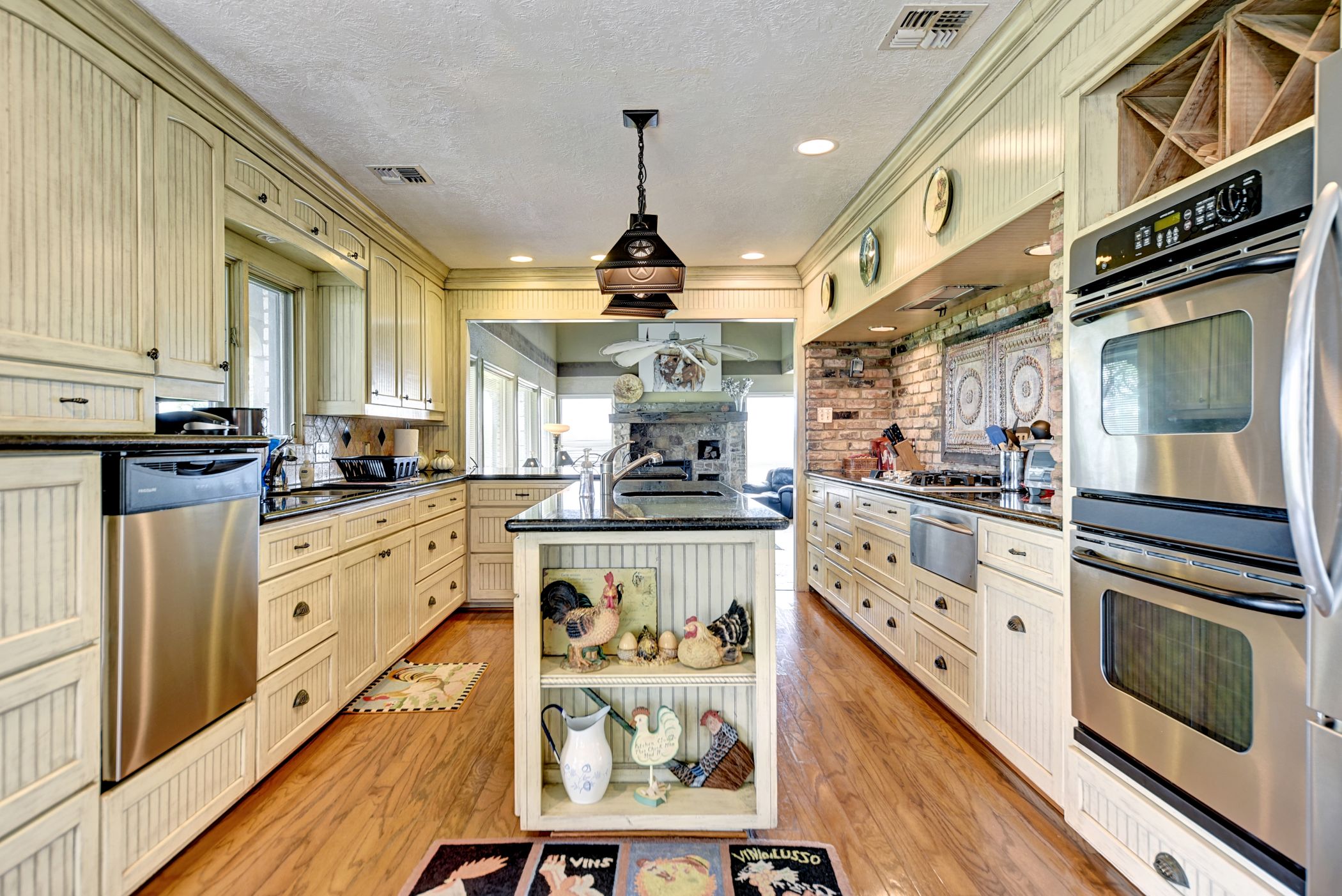 2575 Old Mill Creek Road Brenham, TX 77833 - Photo 6 of 40 a kitchen with stainless steel appliances kitchen island granite countertop a stove a sink and a refrigerator