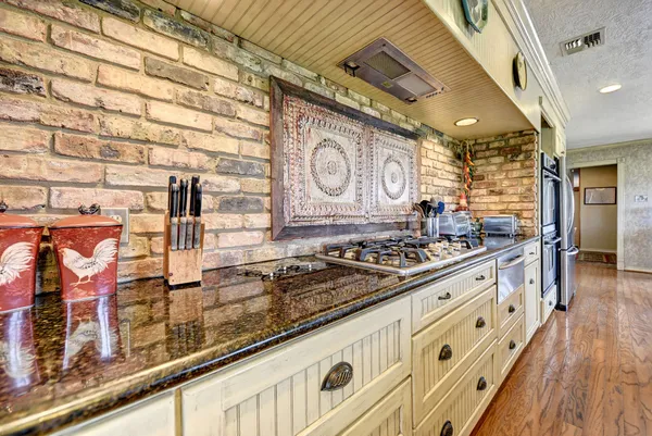 a kitchen with stainless steel appliances granite countertop a stove and cabinets