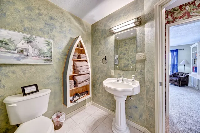a bathroom with a sink mirror and toilet