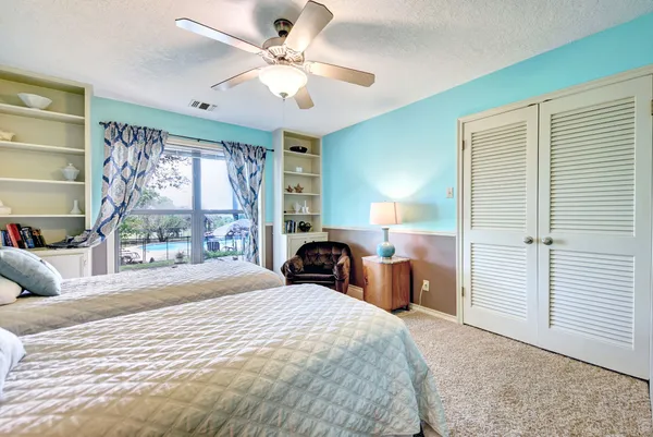 a bedroom with a bed and a large window