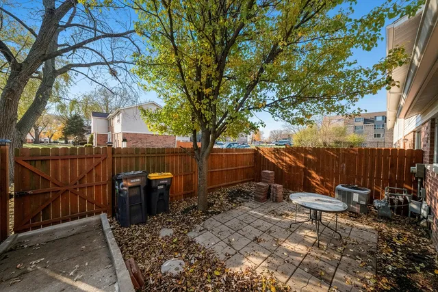 a view of backyard with wooden fence and large trees