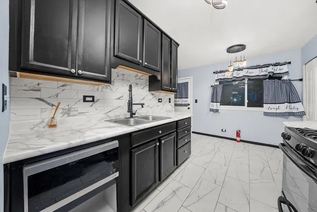 a kitchen with stainless steel appliances a sink stove and cabinets