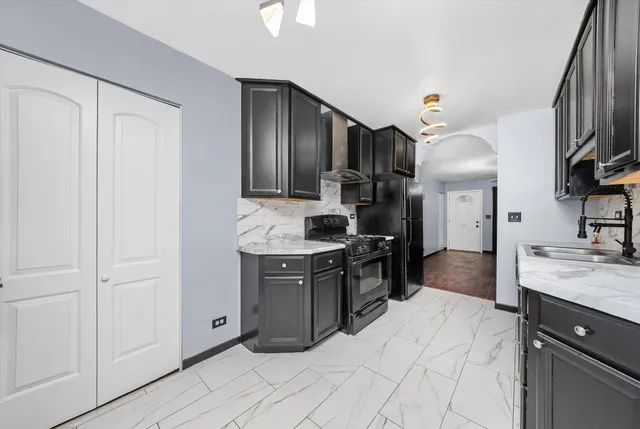 a kitchen with granite countertop a sink stainless steel appliances and white cabinets