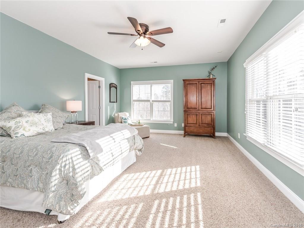 920 Gardenia Street Fort Mill, SC 29708 - Photo 22 of 34 a spacious bedroom with a large bed a chandelier and windows