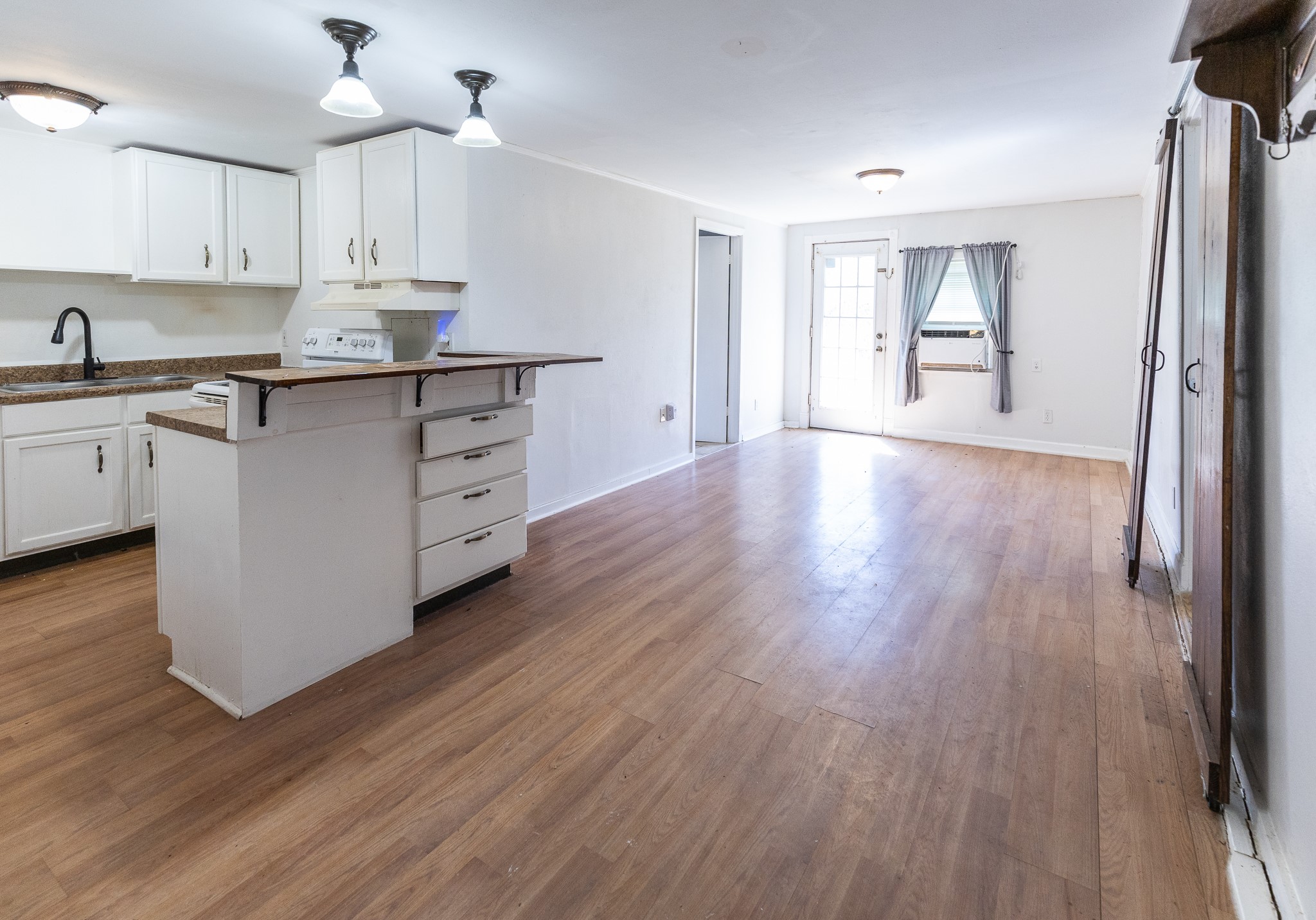 1425 15th Street Huntsville, TX 77340 - Photo 41 of 50 a kitchen with stainless steel appliances granite countertop a refrigerator a sink dishwasher and white cabinets with wooden floor