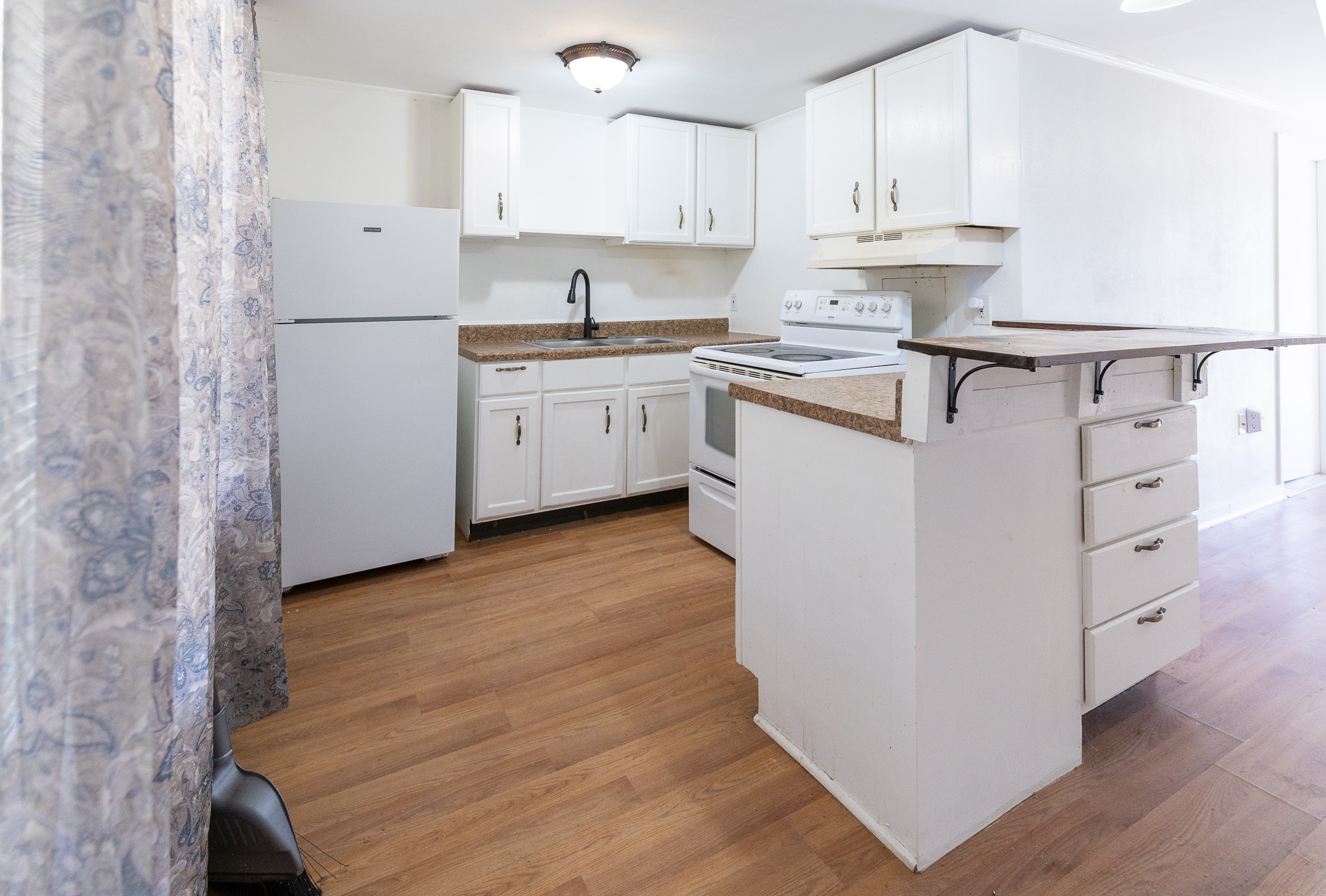 1425 15th Street Huntsville, TX 77340 - Photo 42 of 50 a kitchen with stainless steel appliances granite countertop a sink a stove a refrigerator and white cabinets