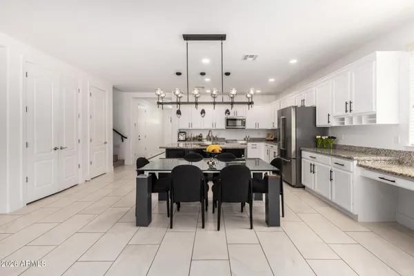 a kitchen with stainless steel appliances kitchen island granite countertop a sink and chairs