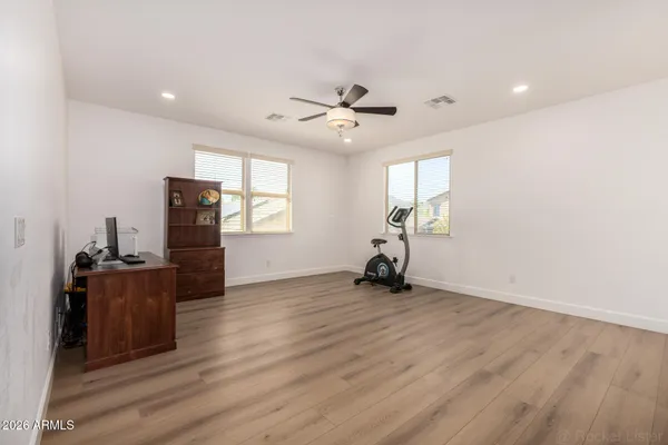 a bedroom with a bed a dresser and a chandelier