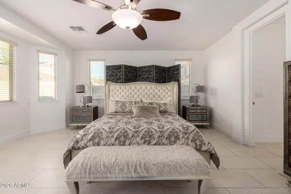 a bedroom with a large bed and a chandelier