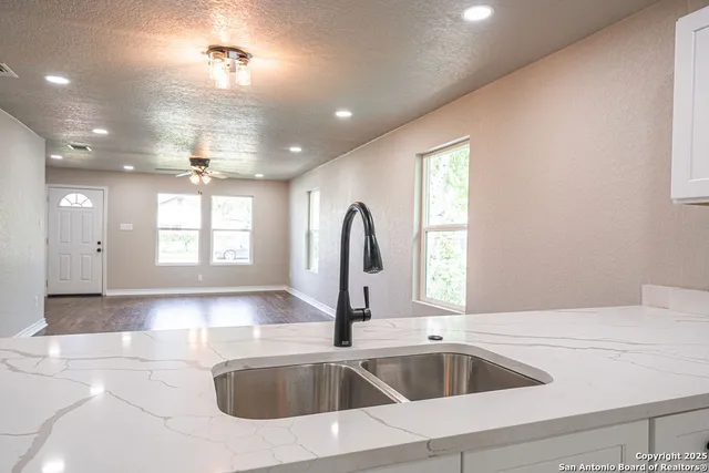 a view of a kitchen with a sink and chandelier