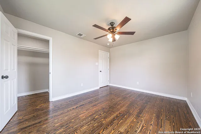 a view of an empty room with wooden floor