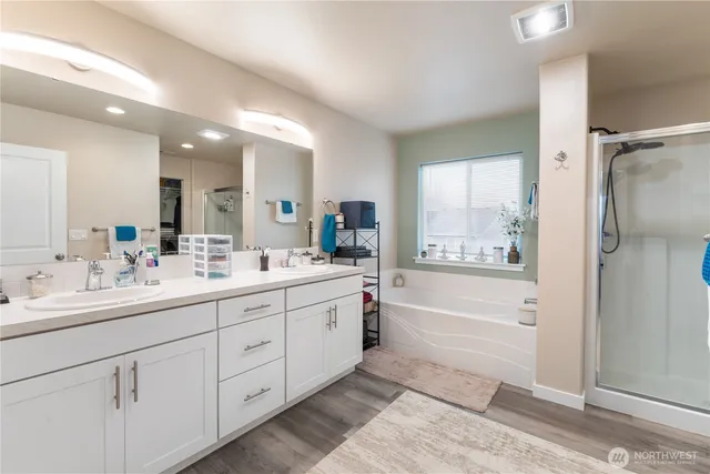 a bathroom with a double vanity sink mirror bathtub and shower
