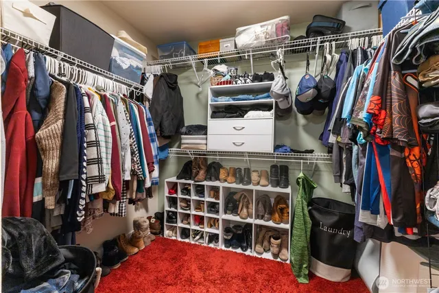 a view of walk in closet with clothes and shoes