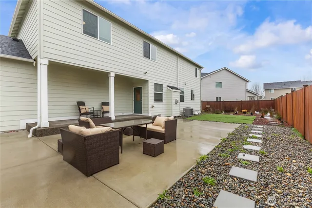 a view of a patio with couches table and chairs with wooden floor and fence