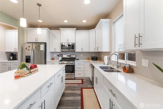 a kitchen with stainless steel appliances a stove refrigerator sink and cabinets