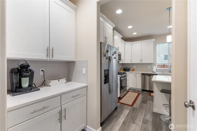 a kitchen with a refrigerator and white cabinets