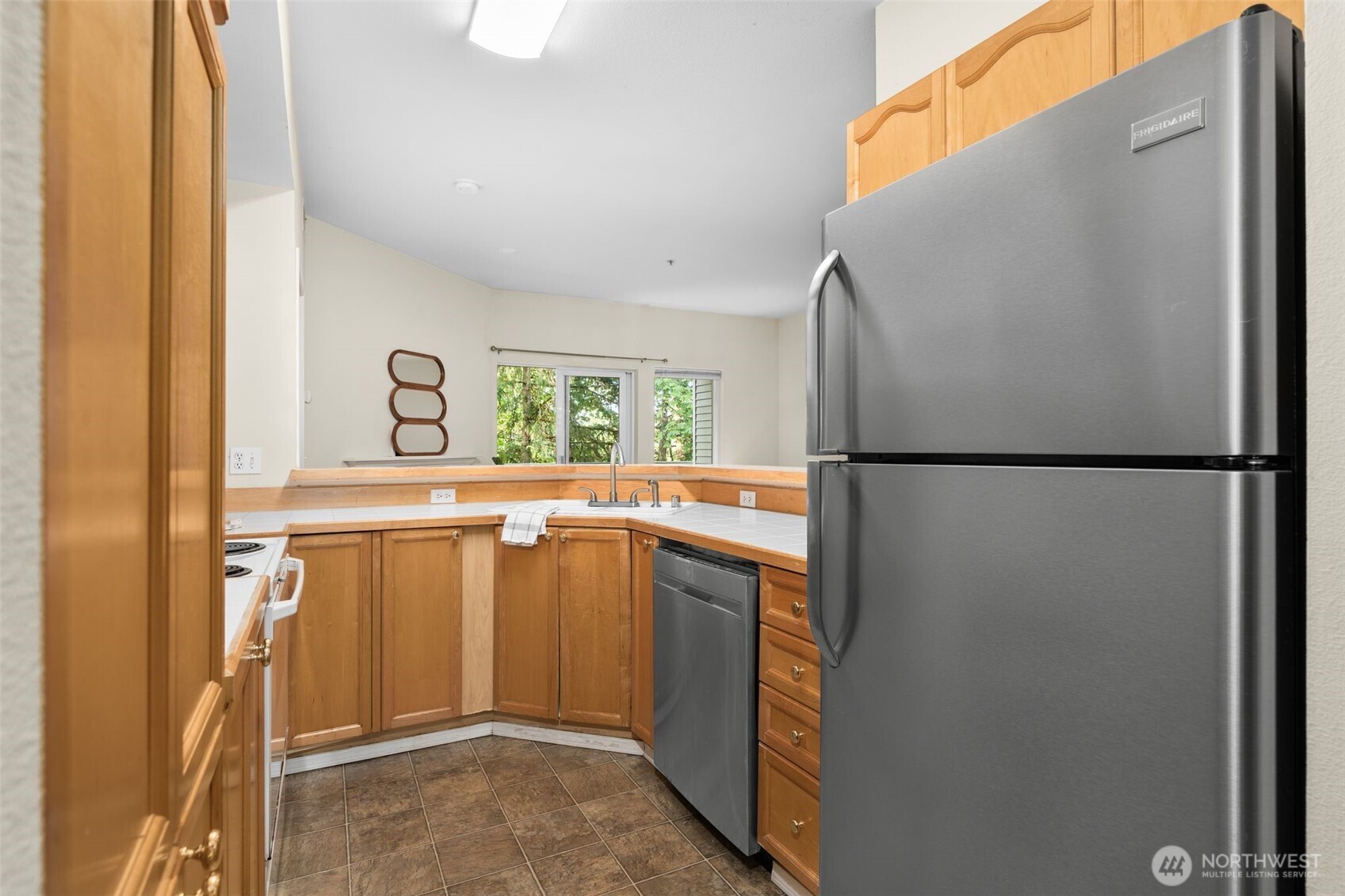 12120 Northeast 172nd Place, Unit L201 Bothell, WA 98011 - Photo 12 of 35 a kitchen with a refrigerator and a sink