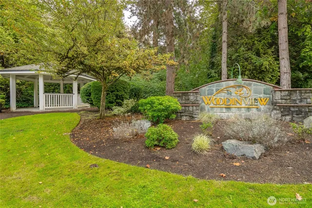 an aerial view of a house with swimming pool and large trees