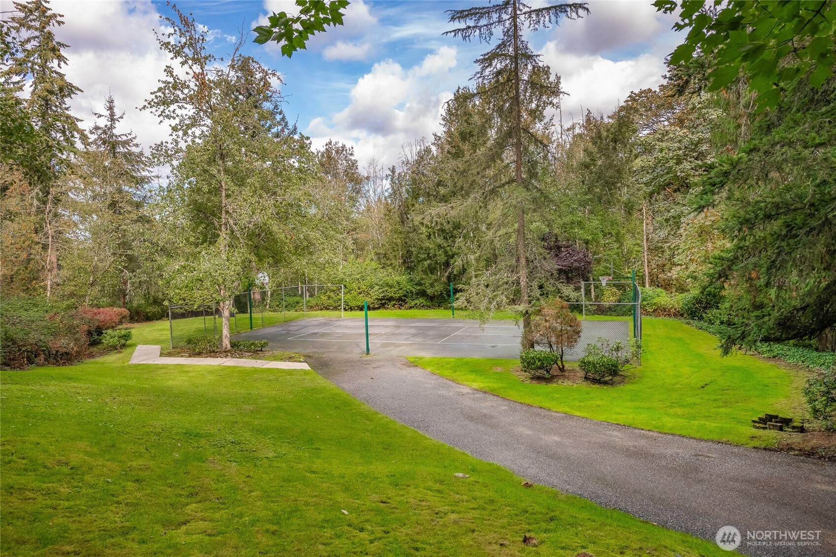 12120 Northeast 172nd Place, Unit L201 Bothell, WA 98011 - Photo 27 of 35 a swimming pool with lots of tress in front of it
