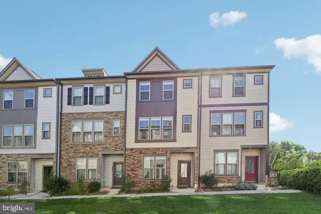 a front view of a residential apartment building with a yard