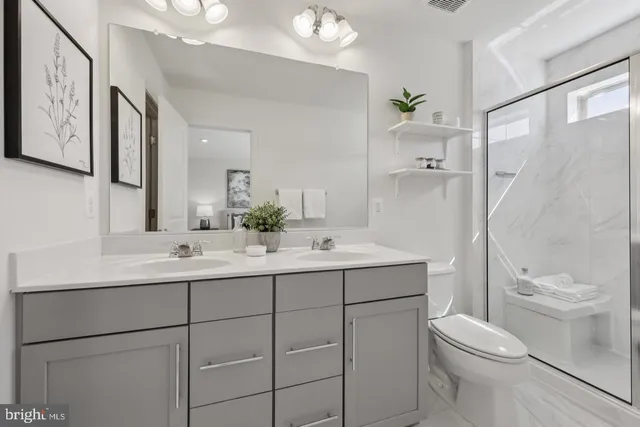 a bathroom with a double vanity sink a toilet and a mirror