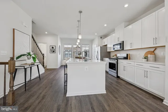 a kitchen with wooden floors and white cabinets
