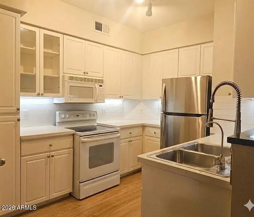 a kitchen with stainless steel appliances granite countertop a sink and a refrigerator