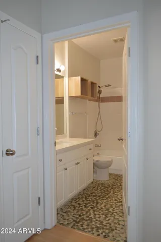 a bathroom with a granite countertop sink a toilet and shower