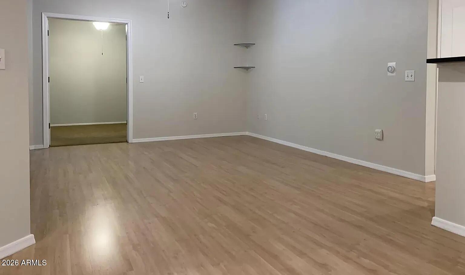 1701 East Colter Street, Unit 263 Phoenix, AZ 85016 - Photo 6 of 65 a view of an empty room with wooden floor and a window