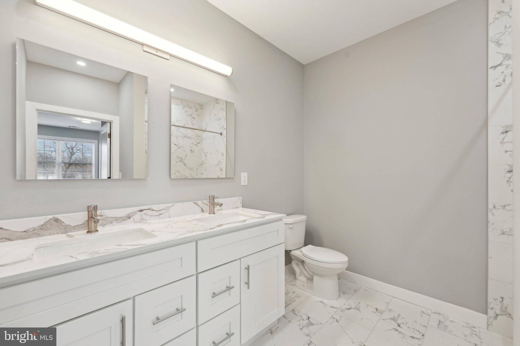 2421 Bristol Road, Unit 2B100 Warrington, PA 18976 - Photo 32 of 50 a bathroom with a double vanity sink toilet and a mirror