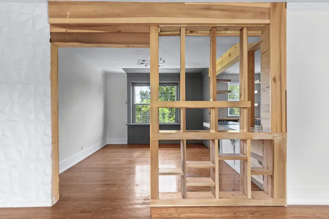 a view of a bedroom with wooden floor and windows