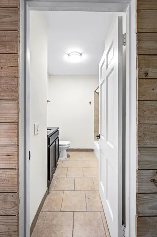 a bathroom with a granite countertop sink a toilet and mirror