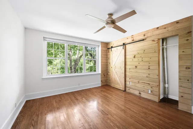 a view of a big room with wooden floor and windows