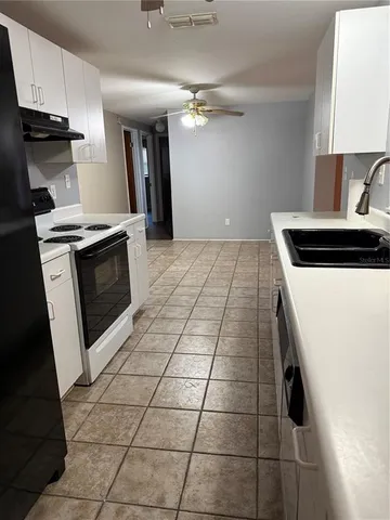 a kitchen with granite countertop a stove a sink and a microwave
