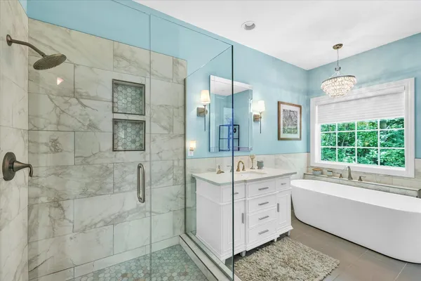 a bathroom with a double vanity sink a large mirror and a bathtub