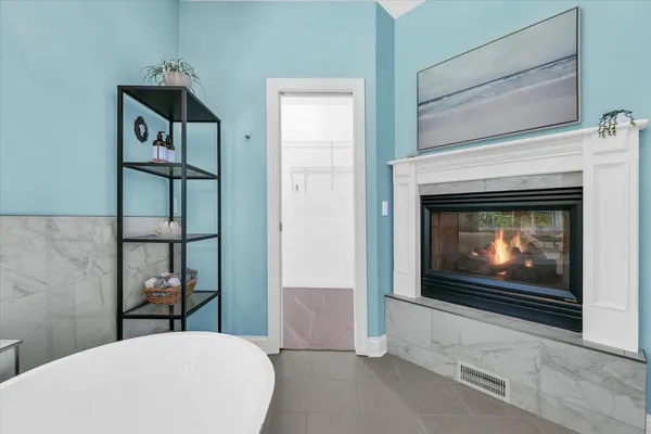 a living room with stainless steel appliances a fireplace and a television