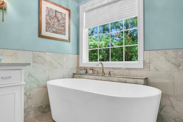 a white bath tub sitting in a bathroom next to a window