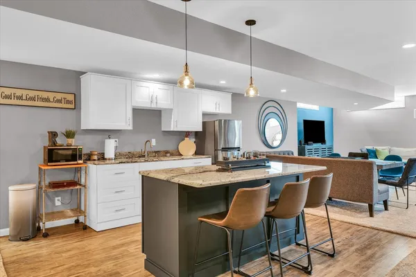 a kitchen with a dining table a sink cabinets and stainless steel appliances