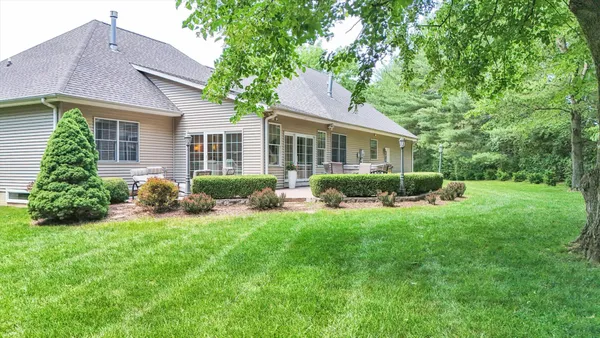 a view of a chairs and table in the back yard of the house