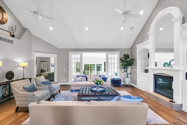 a living room with furniture fireplace and large windows