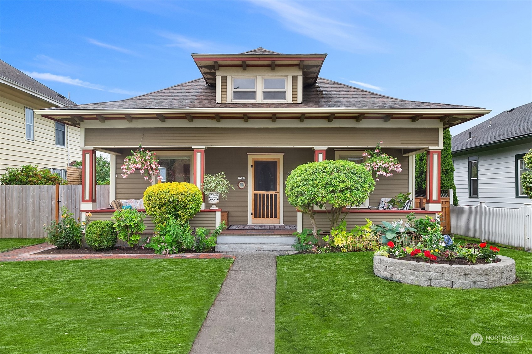 a front view of a house with a garden and plants