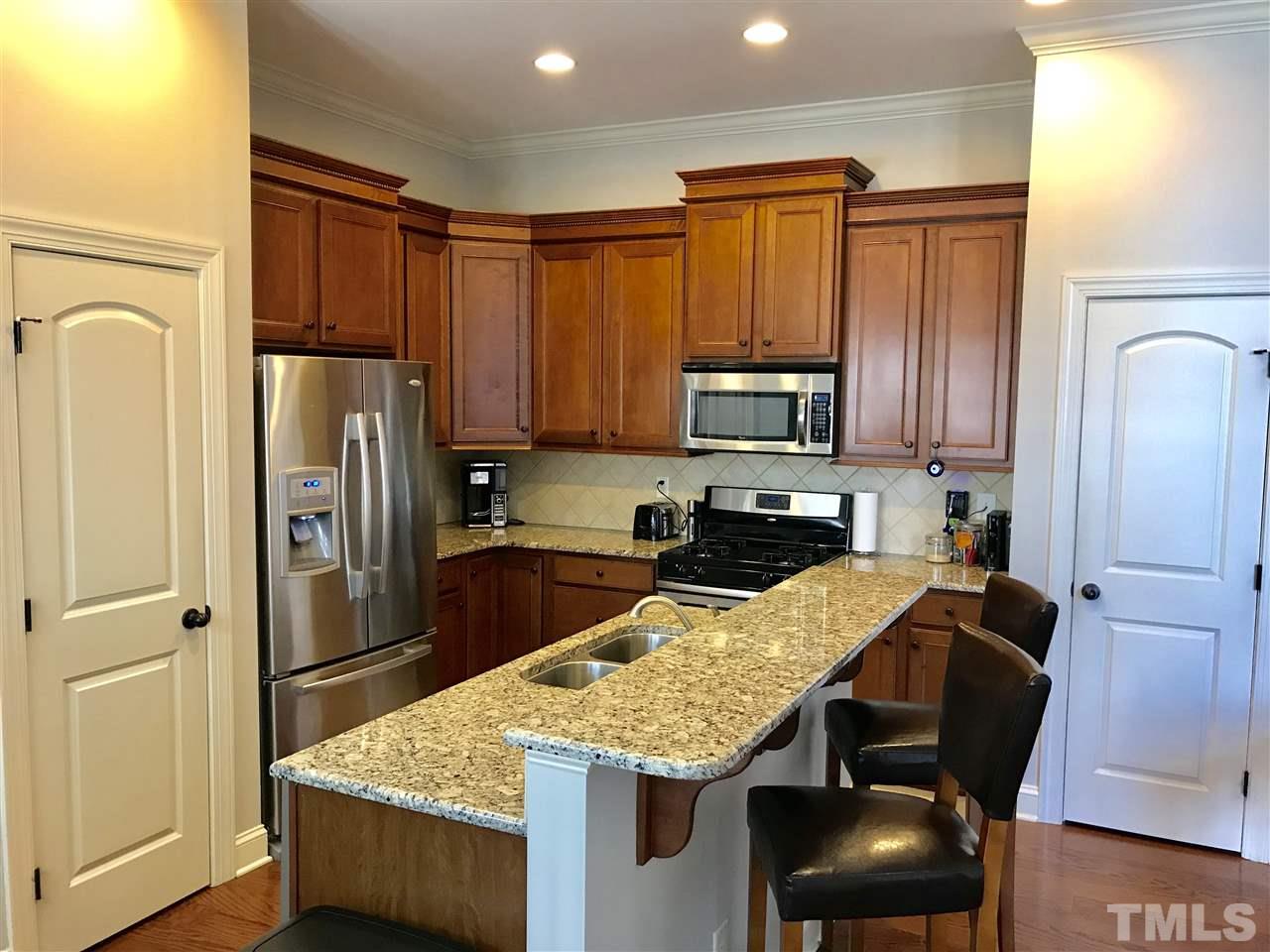 840 Historian Street Raleigh, NC 27603 - Photo 4 of 25 a kitchen with stainless steel appliances granite countertop a refrigerator stove microwave and sink