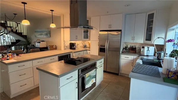 a kitchen with stainless steel appliances granite countertop a sink a stove and a refrigerator