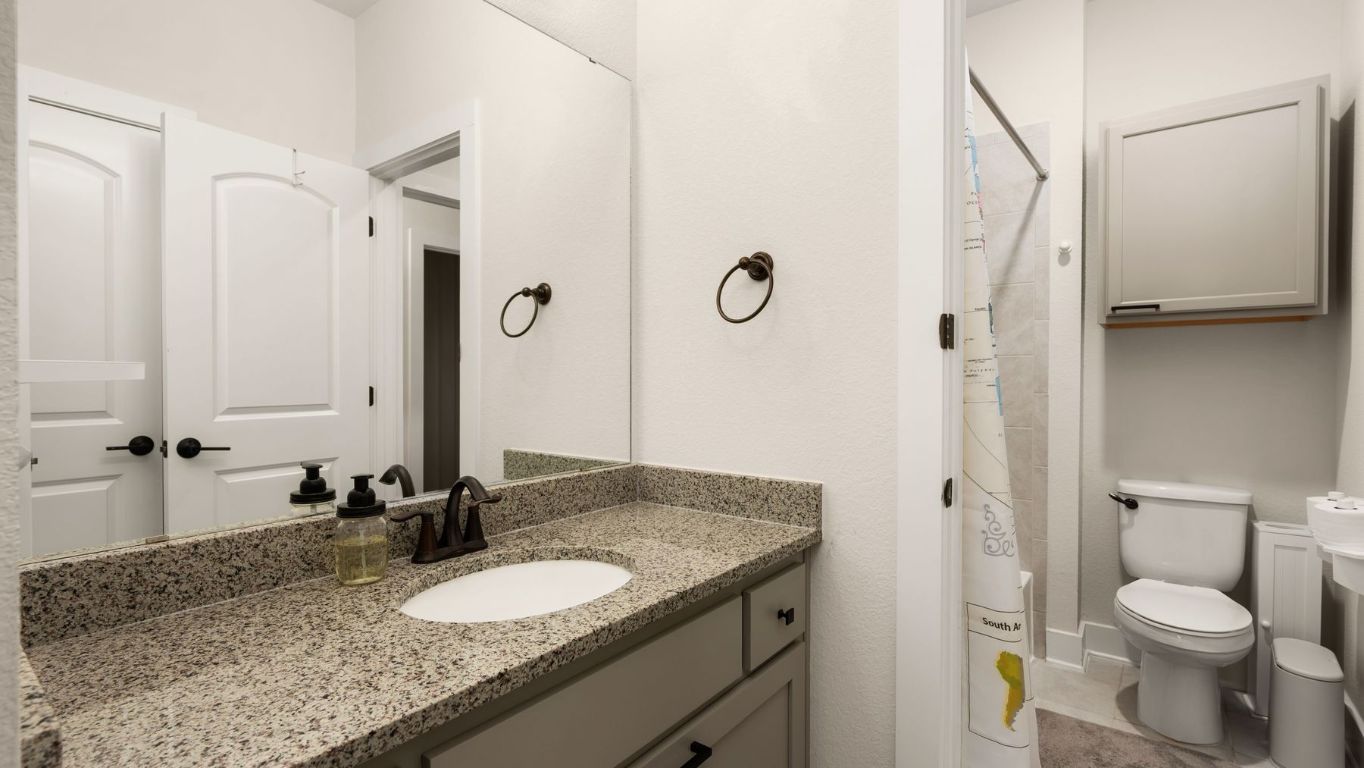 1925 Sorvino Walk Leander, TX 78641 - Photo 30 of 36 a bathroom with a granite countertop sink toilet and shower