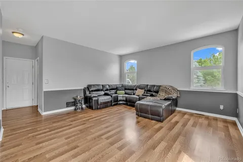 a living room with furniture and wooden floor