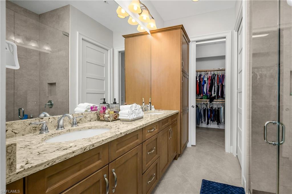 6552 Dominica Drive, Unit 101 Naples, FL 34113 - Photo 18 of 50 a en suite bathroom with a granite countertop sink and a mirror