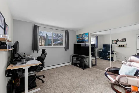 a living room with furniture a flat screen tv and a window