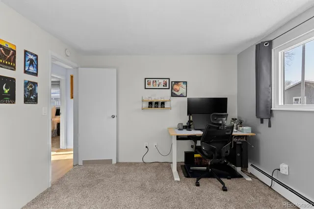 a view of a workspace with furniture and a window